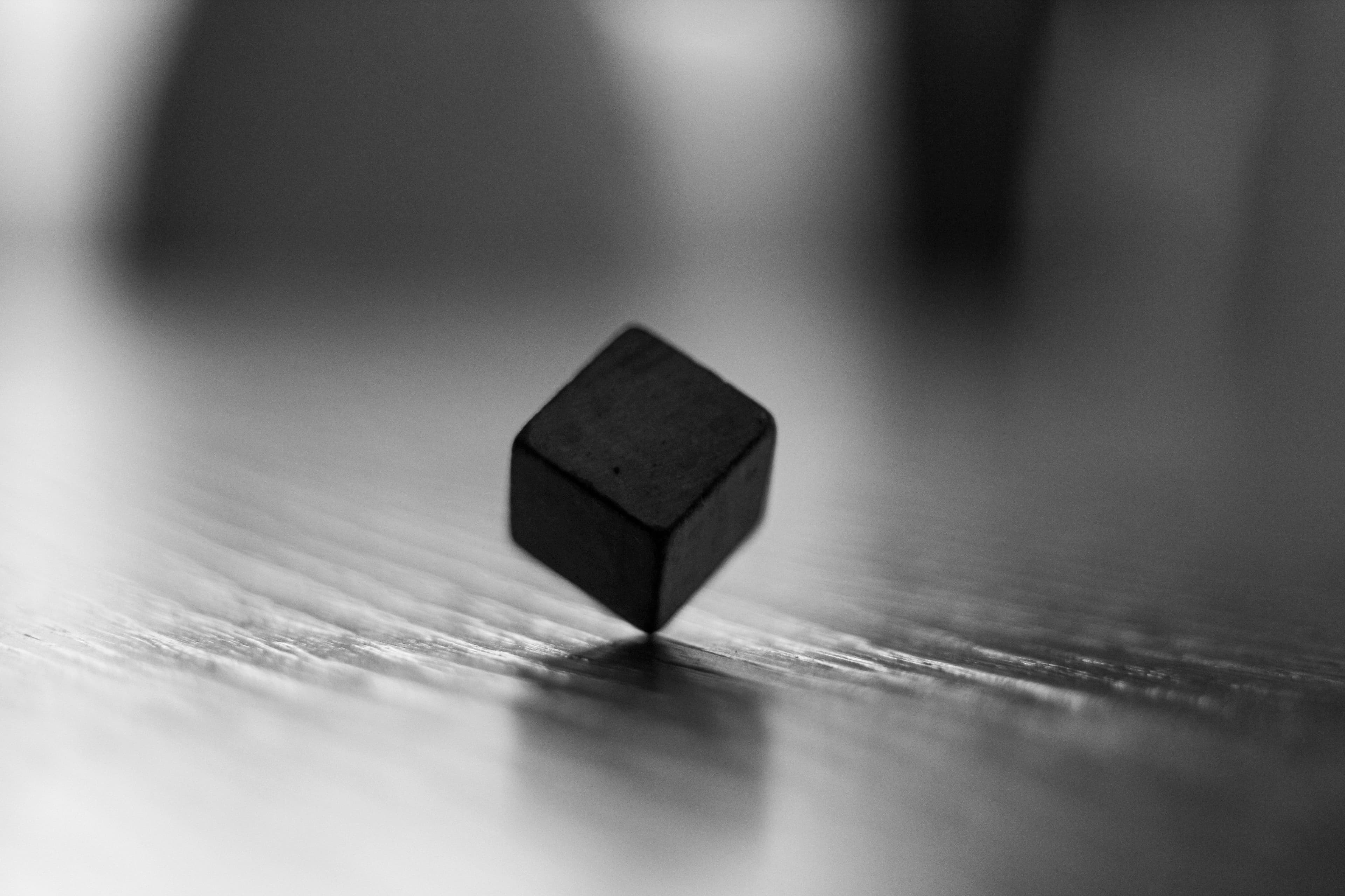 A black die with no numbers spinning